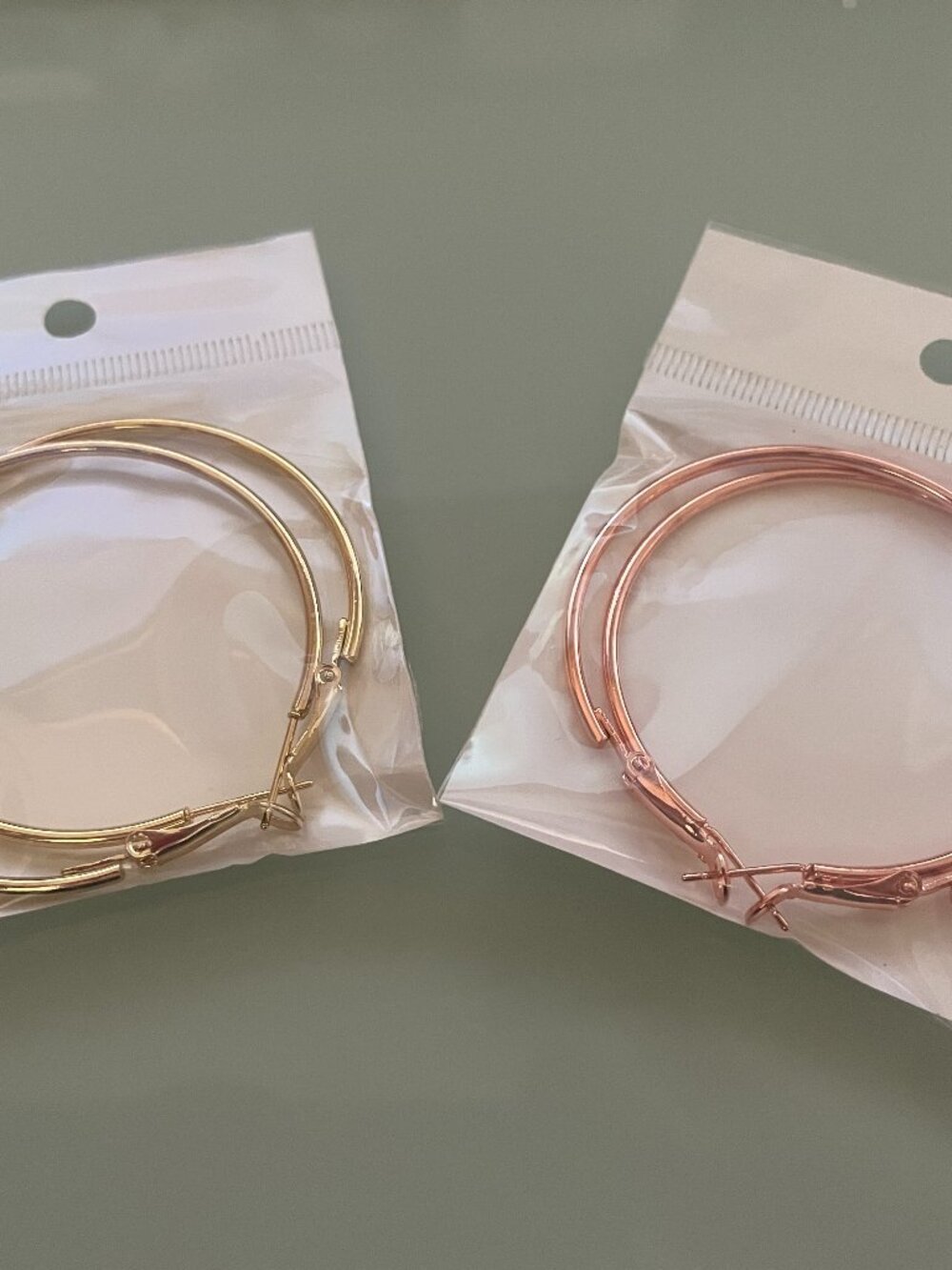 2 pairs of hoop earrings. 2 inch diameter. Gold-tone and rose-gold tone.